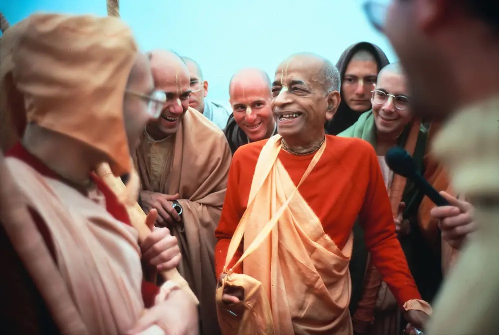 Srila Prabhupada laughing with his disciples on a morning walk